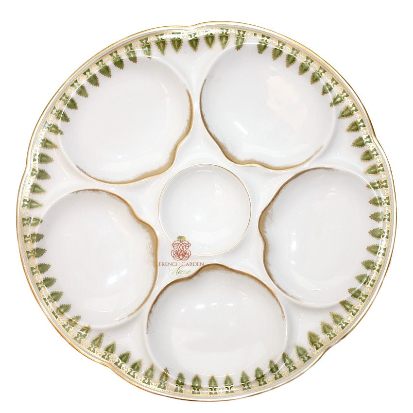 Antique French Limoges hand-painted oyster plate with green and gold details on an off-white background, featuring five wells around a central condiment well.