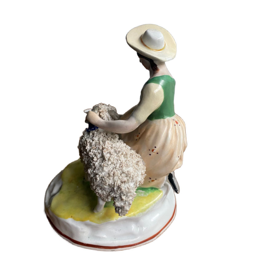 beautifully made in 1835 by James Dudson, Hanley, Stoke on Trent, Staffordshire, England. This charming and rare Staffordshire pottery figure captures a pastoral scene of traditional sheep shearing. An exceptional figure,  a shepherdess, holding a sheep ready for shearing, offering a glimpse into rural life of the period.