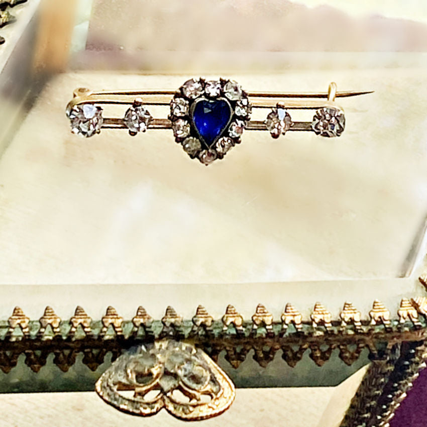 Antique Victorian bar pin in gold, set with sparkling paste stones and a vivid blue heart. Timeless romantic jewelry