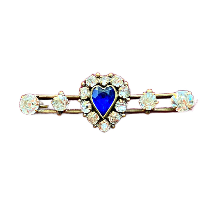Antique Victorian bar pin in gold set with sparkling paste stones and a vivid blue heart. Timeless romantic jewelry.