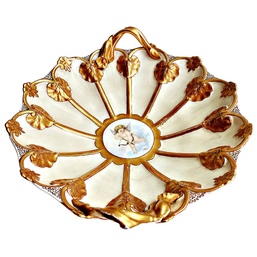 Antique JPL Jean Pouyat Limoges porcelain bowl with hand-painted cherub and lavish gilt lily pad handles. side view