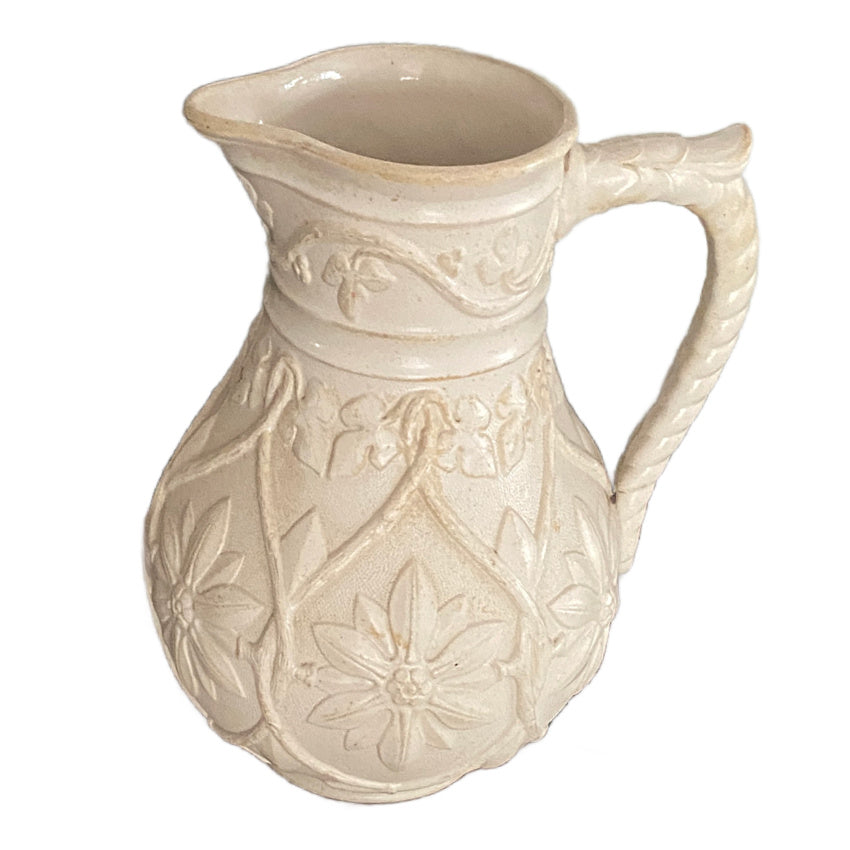 Antique buff stoneware pitcher raised floral motifs rope style handle detail