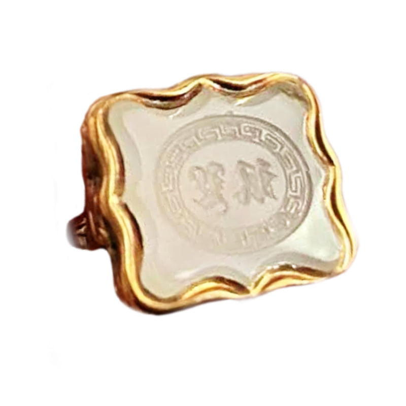 Close-up of white agate seal with Greek key border and engraved initials