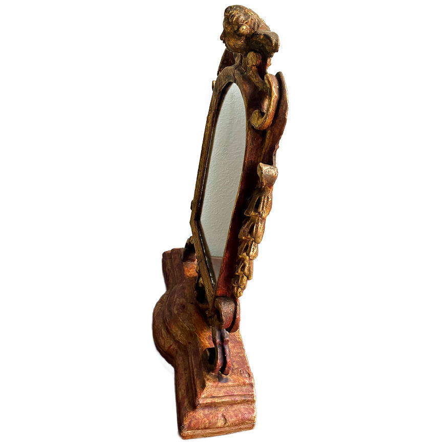 Side view of gilt cherub detailing on antique French style standing mirror