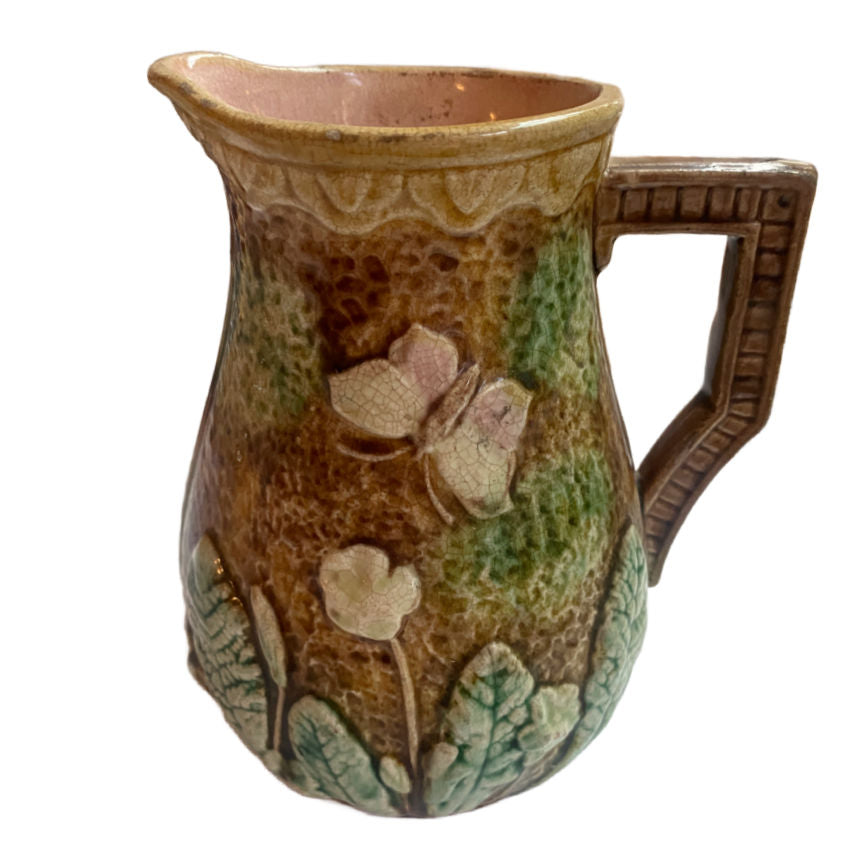 Antique French Majolica Pitcher with violets and butterflies, pink interior and aged patina—romantic 19th-century French country charm.
