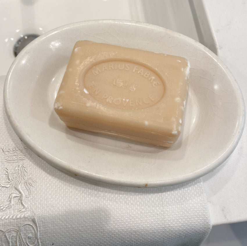 Antique ironstone soap dish with French soap and an antique towel with a royal monogram