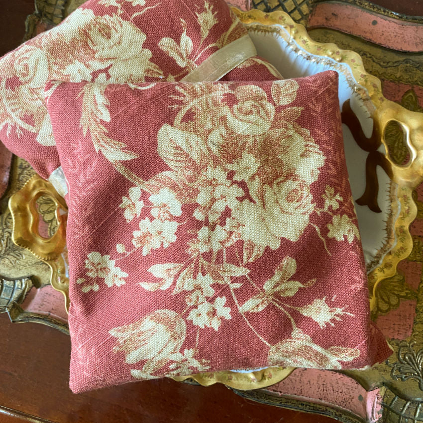 Handmade linen lavender sachet with romantic vintage rose print, filled with fragrant lavender on an antiqueLimoges plate