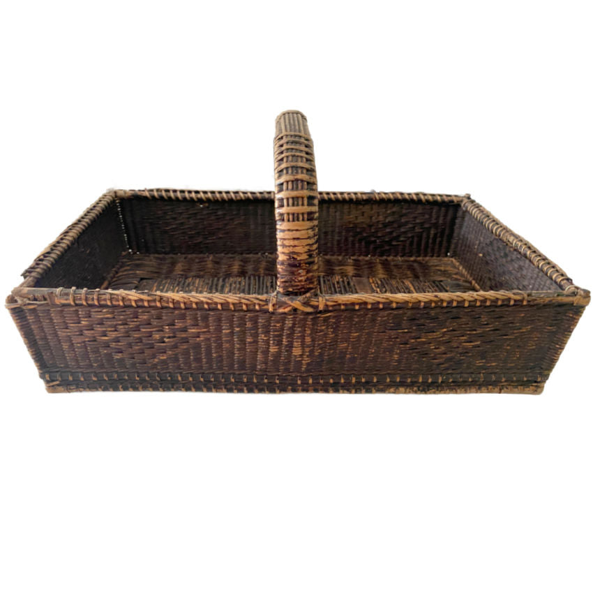 A rare and soulful 19th Century Antique Shallow Handwoven Basket woven by hand with remarkable skill and artistry. Once used for holding flatware or linens, this beautifully aged piece bears the marks of time with quiet grace. Its dark, time-worn patina and exquisite texture tell the story of generations past, while the old string repairs—done with care long ago—reveal the devotion of those who cherished and preserved it.