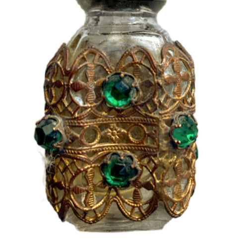 Exquisite Art Deco miniature perfume bottle adorned with emerald glass jewels and intricate gilt filigree. A romantic collector’s treasure of timeless elegance.
