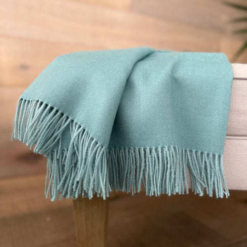 Indulge in this handwoven Sea Glass alpaca throw, crafted from the finest baby alpaca for unmatched softness, warmth, and timeless sophistication.