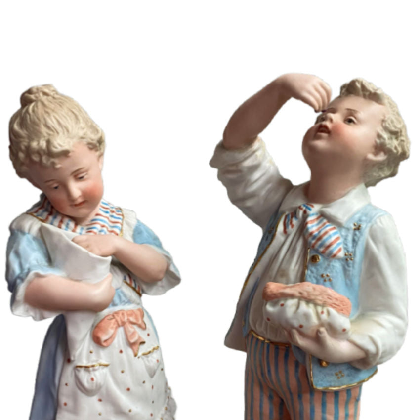 Rare matched pair of antique Gebrüder Heubach bisque figurines of a girl and boy enjoying sweets. Exquisite German craftsmanship, circa 1900.