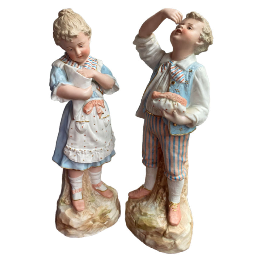 Rare matched pair of antique Gebrüder Heubach bisque figurines of a girl and boy enjoying sweets. Exquisite German craftsmanship, circa 1900.