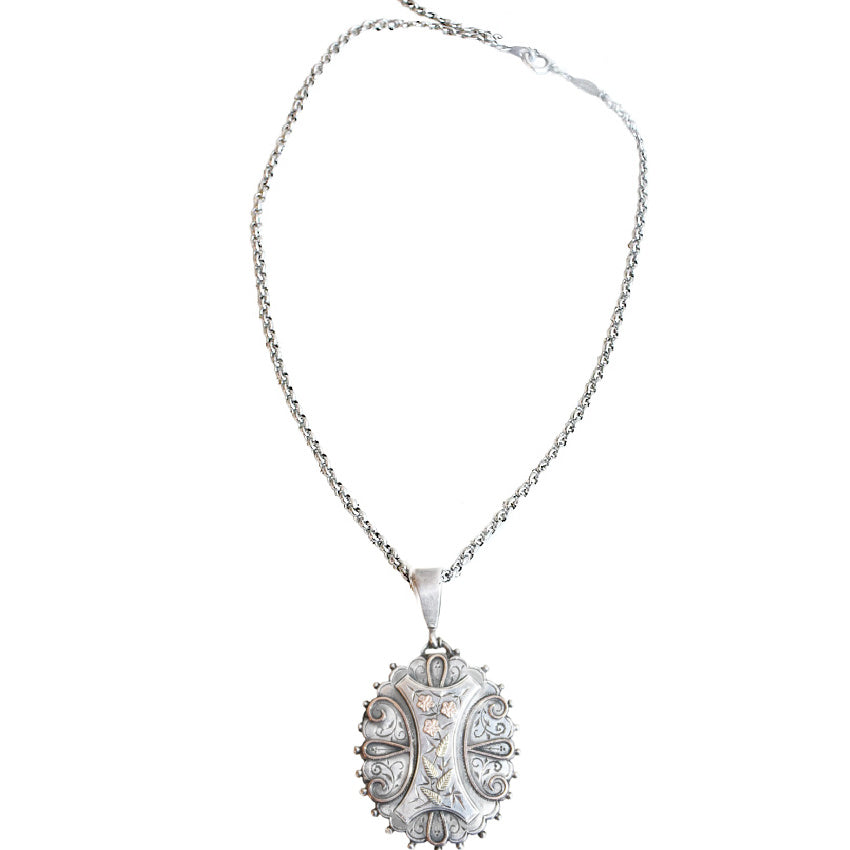 Antique English silver and rose gold locket necklace with Victorian charm. A timeless sentimental heirloom jewelry piece with historic elegance.