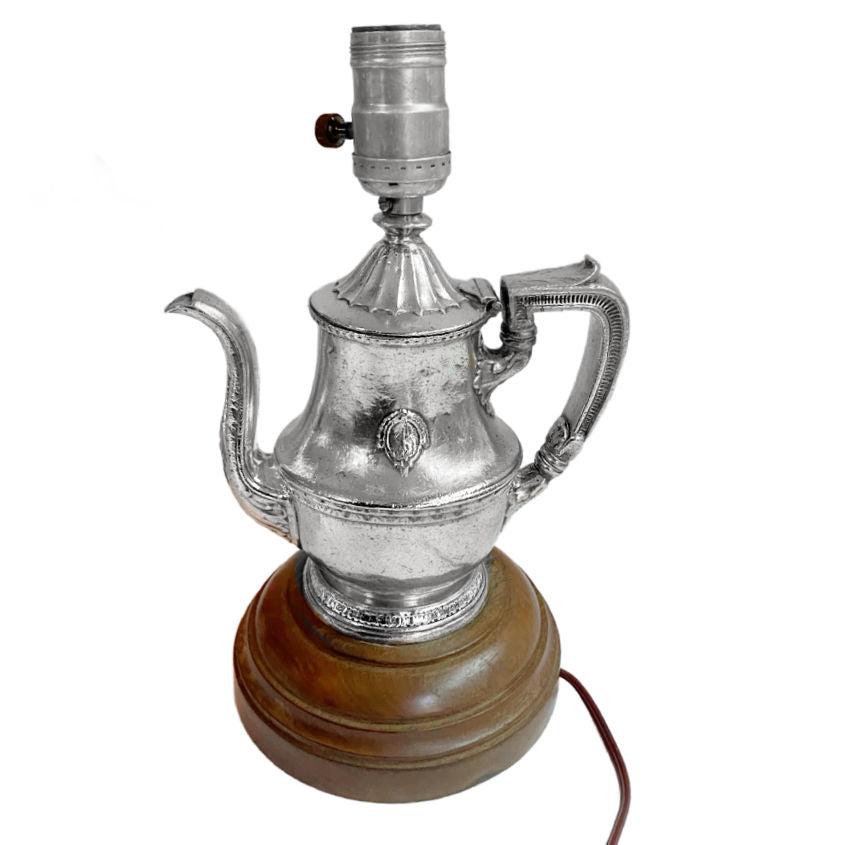 Vintage 1940s hotel silver tea pot lamp on wood base, a chic repurposed design blending mid-century elegance and timeless hospitality charm.