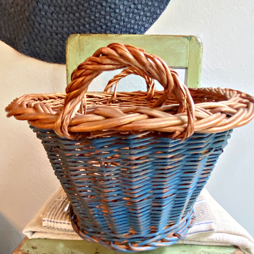 Vintage Dutch basket close-up of integrated handles and faded Delft blue handwoven wicker