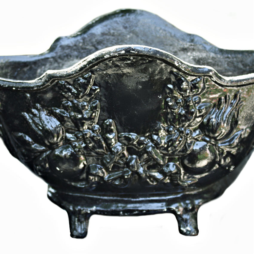 close detail of laurel garland motif on antique cast iron planter