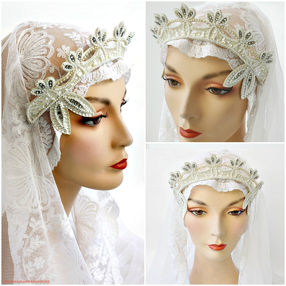 A vintage beaded and rhinestone tiara headpiece with white seed beads, pearls, and glittering paillettes, displayed on a mannequin head wearing a white veil.