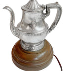 Detail of fluted spout and elegant handle and hotel logo highlighting hotel silver craftsmanship