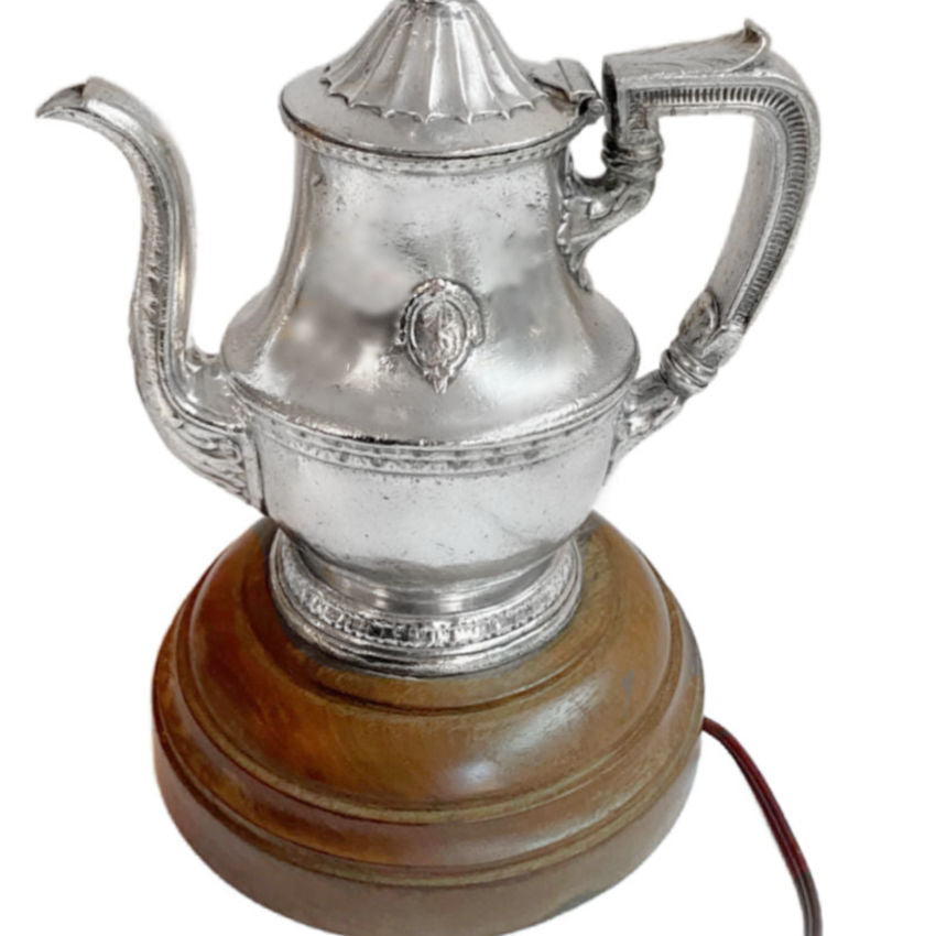 Detail of fluted spout and elegant handle and hotel logo highlighting hotel silver craftsmanship