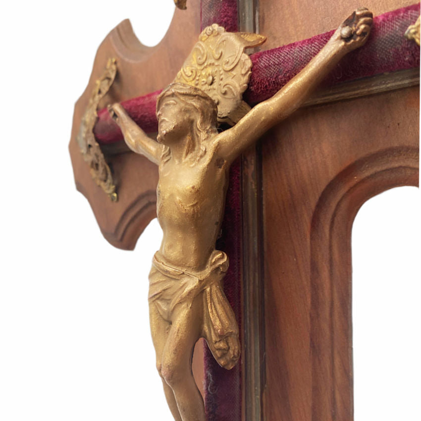 Profile view of bronze Corpus on antique French crucifix mounted on red velvet cross with decorative cross caps