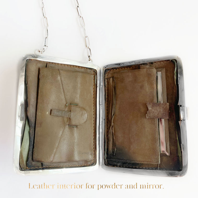 Antique sterling silver ladies' evening purse compact with a floral design on the front, a leather pouch, and a chain and original powder puff.