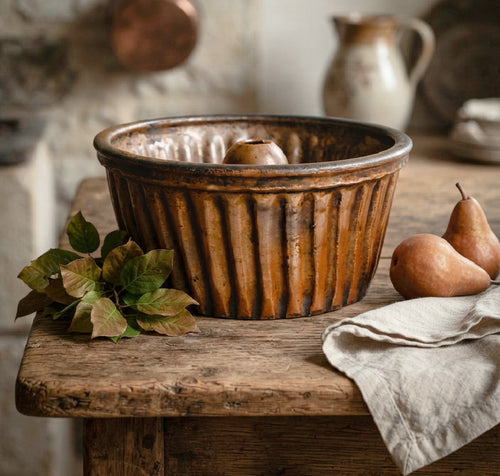 19th century French Alsace pottery cake mold on a French country table with pears, autumn leaves and linen towel