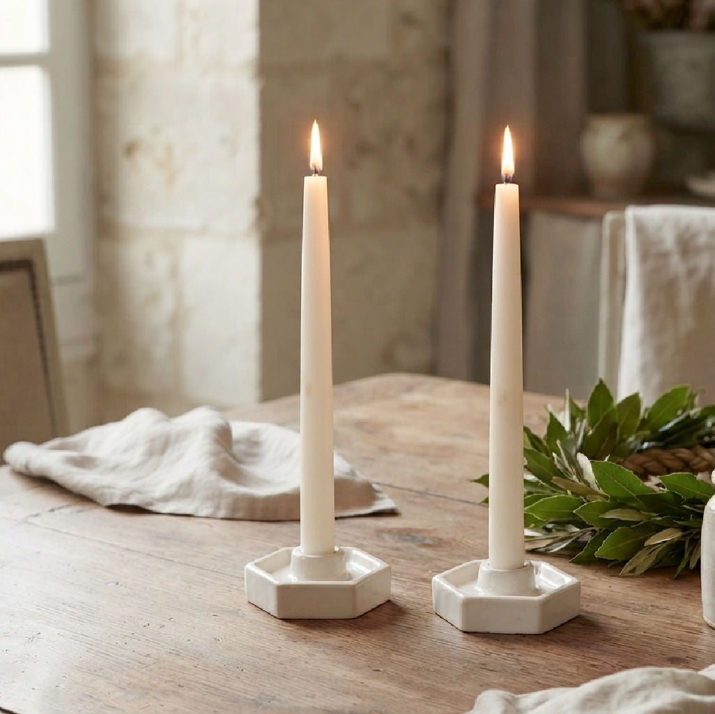 Abeille white pottery taper candle holders with candles, linen, and green wreath
