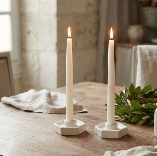 Abeille white pottery taper candle holders with candles, linen, and green wreath