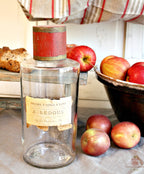 Antique French apothecary jar styled with pottery bowl and apples and collected objects
