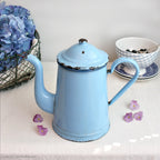 Decorative antique French coffee pot in striking blue enamel, navy rim detail, sculptural goose-neck form, perfect for rustic European kitchen display.