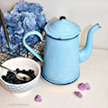 Antique French enamel coffee pot in deep ocean blue with navy accent rim, elegant curved spout, rustic century-old farmhouse kitchen collector piece, shown with blueberries, pansies and hydrangeas