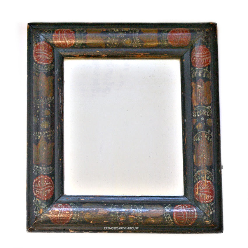 An early antique hand painted wood courting mirror with a country floral design, featuring large red tulips and foliate patterns in French Country colors.