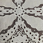 Antique embroidered lace textile with intricate cutwork craftsmanship close detail