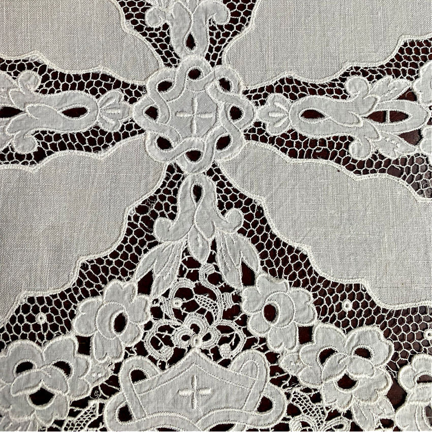 Antique embroidered lace textile with intricate cutwork craftsmanship close detail