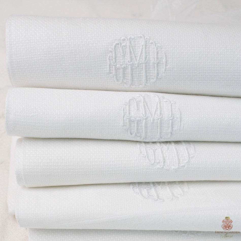 Antique white cotton piqué monogrammed guest towel with hand embroidered GMD initials and damask border