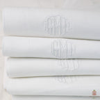 Antique white cotton piqué monogrammed guest towel with hand embroidered GMD initials and damask border