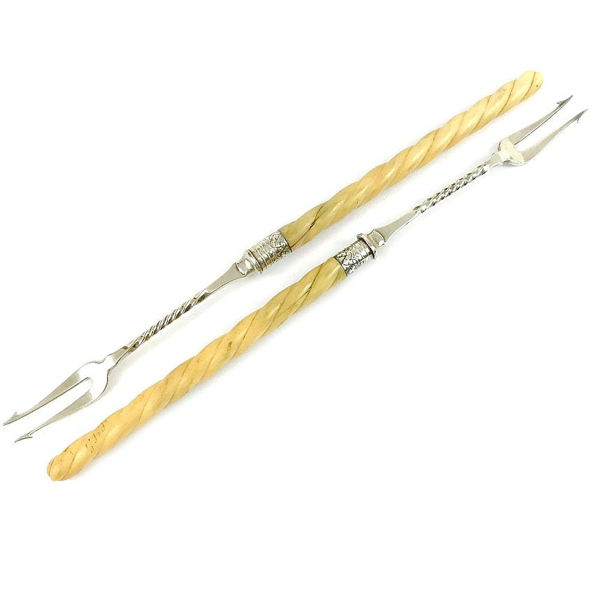 A pair of antique Victorian silver plated pickle hors d'oeuvres serving forks with twisted bone handles and decorative silver clover designs on the collars.