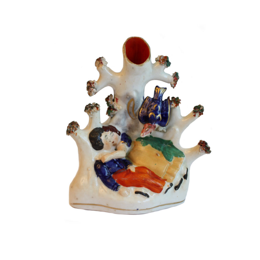 An Early 19th Century Staffordshire Spill Vase featuring a hand-painted scene of a couple sleeping in each other&#39;s arms under a tree, with a blue bird and a gray tree trunk.