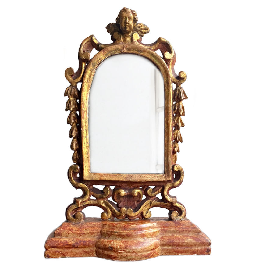 Antique hand-carved gesso and gilt wood cherub standing mirror with ornate scrollwork and warm patina—romantic European décor for elegant, timeless interiors.