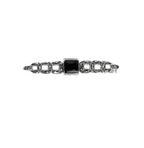 A sterling silver bar pin with a central black onyx stone and small marcasite decorations.