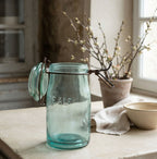 Antique aqua French canning jar styled with vintage pottery and natural linen