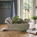 Styled French Provençal kitchen scene featuring antique work box holding silver, linen napkins, and herbs