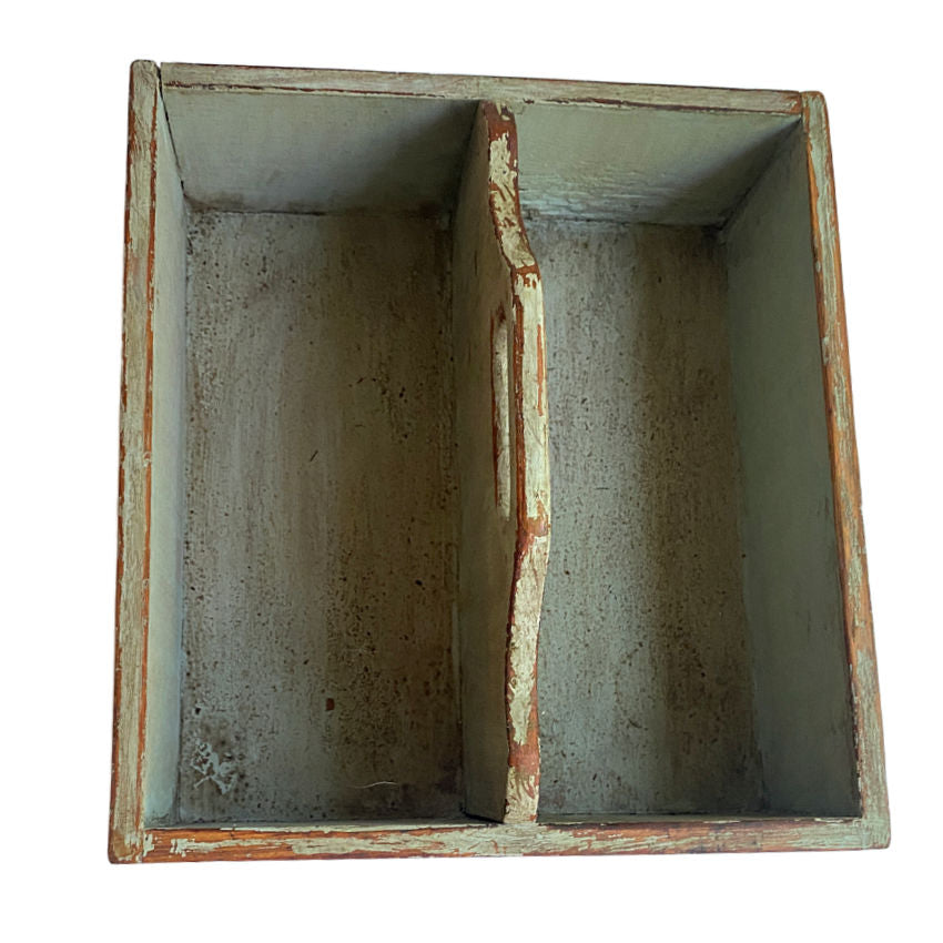 Interior view of antique wooden work box with softened green finish and natural wood grain and worn handle
