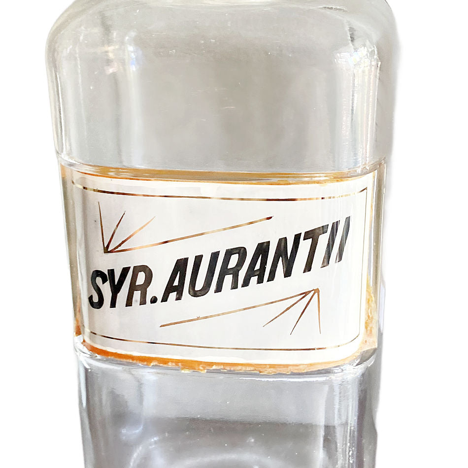 Close up of historic Syrup Aurantii pharmaceutical label preserved beneath glass