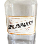 Close up of historic Syrup Aurantii pharmaceutical label preserved beneath glass