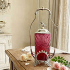 Antique James W. Tufts silver plate cranberry glass pickle castor styled on a French room table with pink roses, chandelier light, and timeless elegance