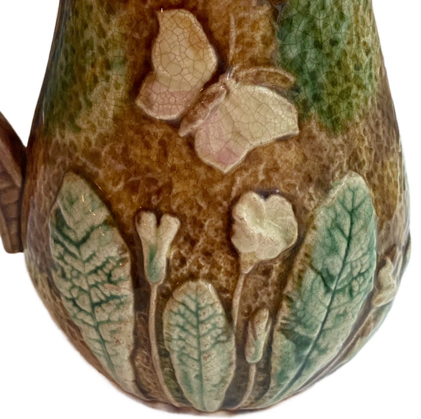 Antique French Majolica Pitcher with violets and butterflies, pink interior and aged patina—romantic 19th-century French country charm.