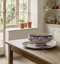 Antique Moustiers faience sauce boat with in a country kitchen with light streaming in, on an antique French table