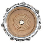 Close-up of raised shell detail on antique silver-plated champagne coaster silver button light wood