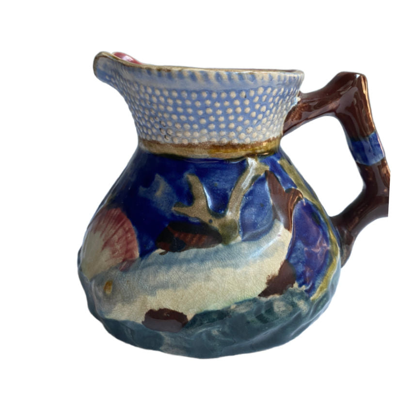 Charming English Majolica pitcher by Shorter & Sons, with raised fish and shell design in ocean hues—Staffordshire coastal beauty.